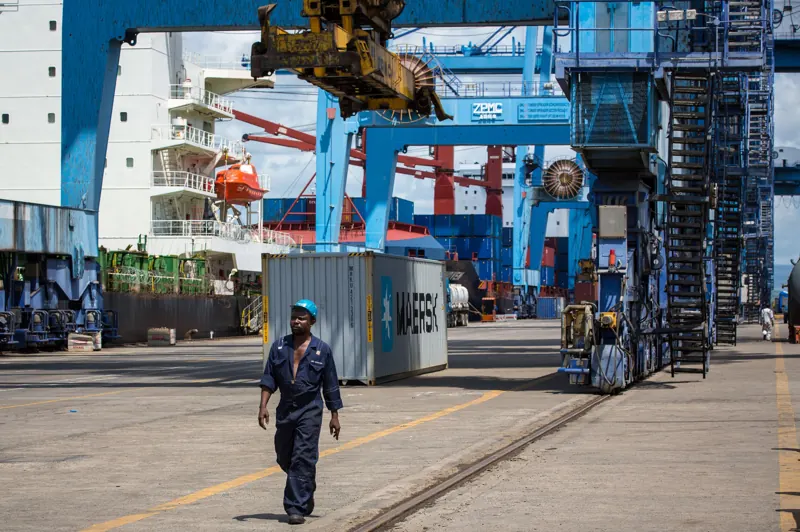 A port worker walks past a container crane at the Port of Mombasa